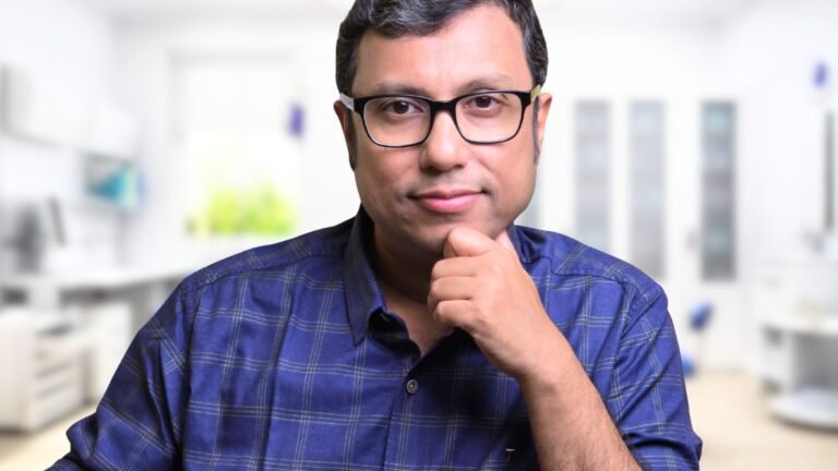 Man in blue checkered shirt Dr-Manas-Chakrabarti